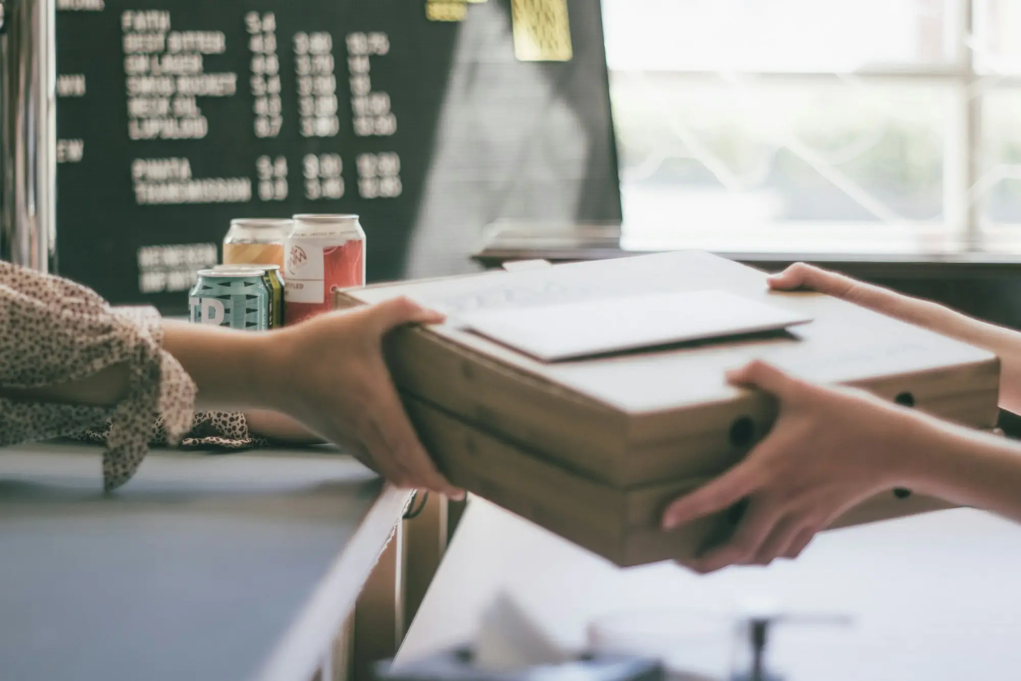 Online store owner handing over boxed orders at the counter
