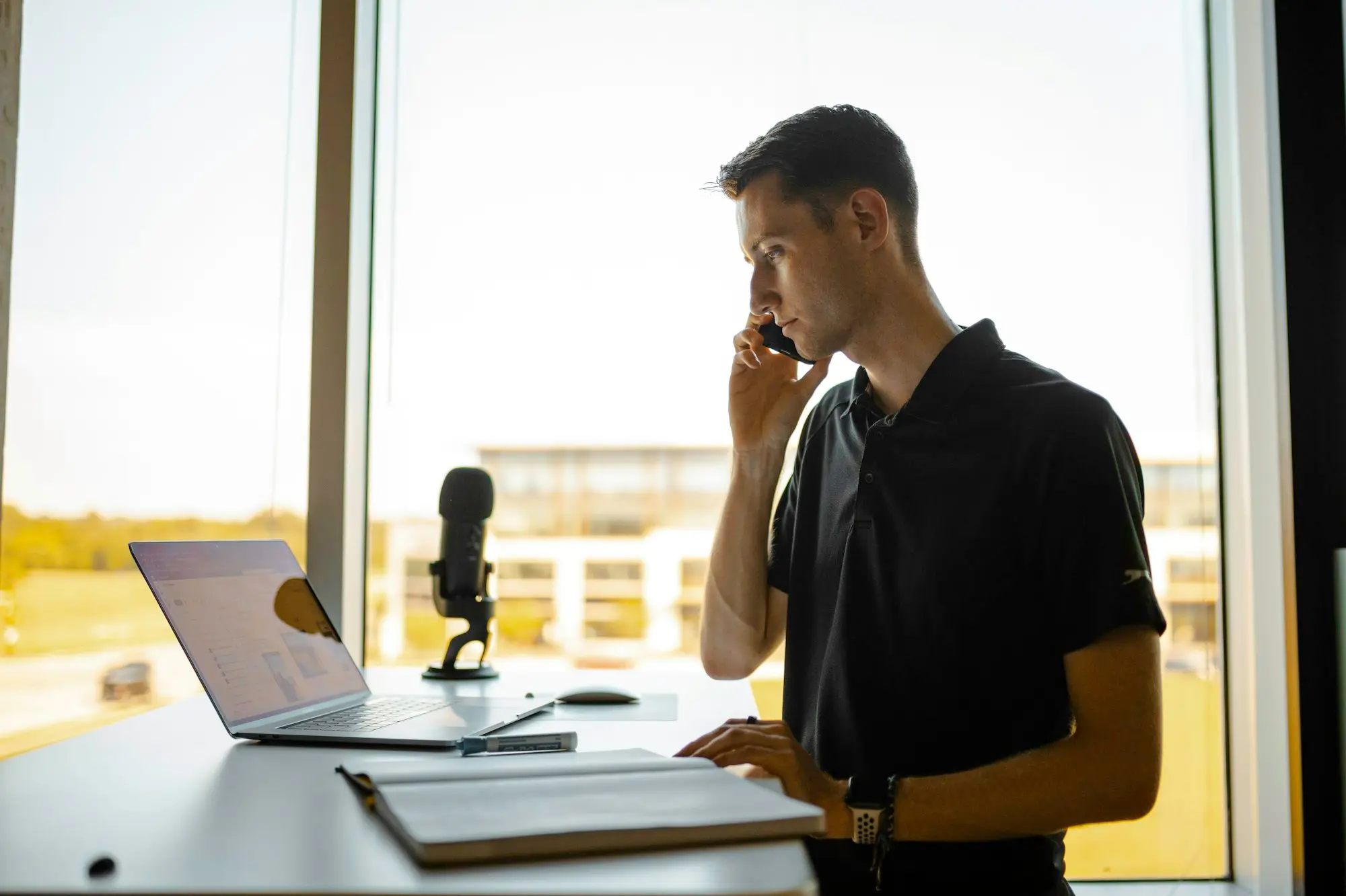 Business owner on a phone call to a lender beside his laptop