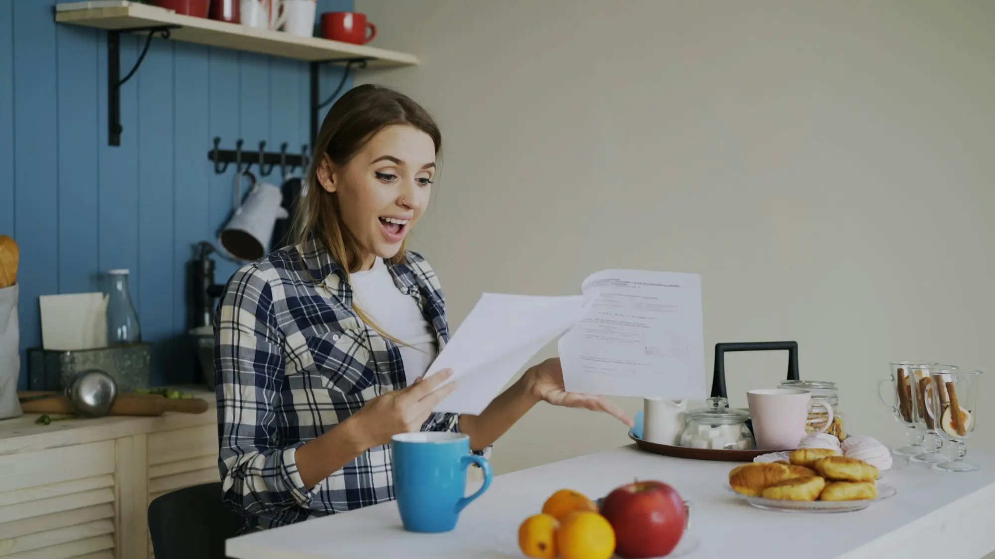 Business owner reviewing bills with a coffee at the kitchen table